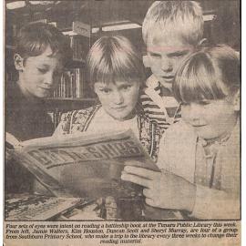 Four sets of eyes were intent on reading a battleship book at the Timaru Public Library