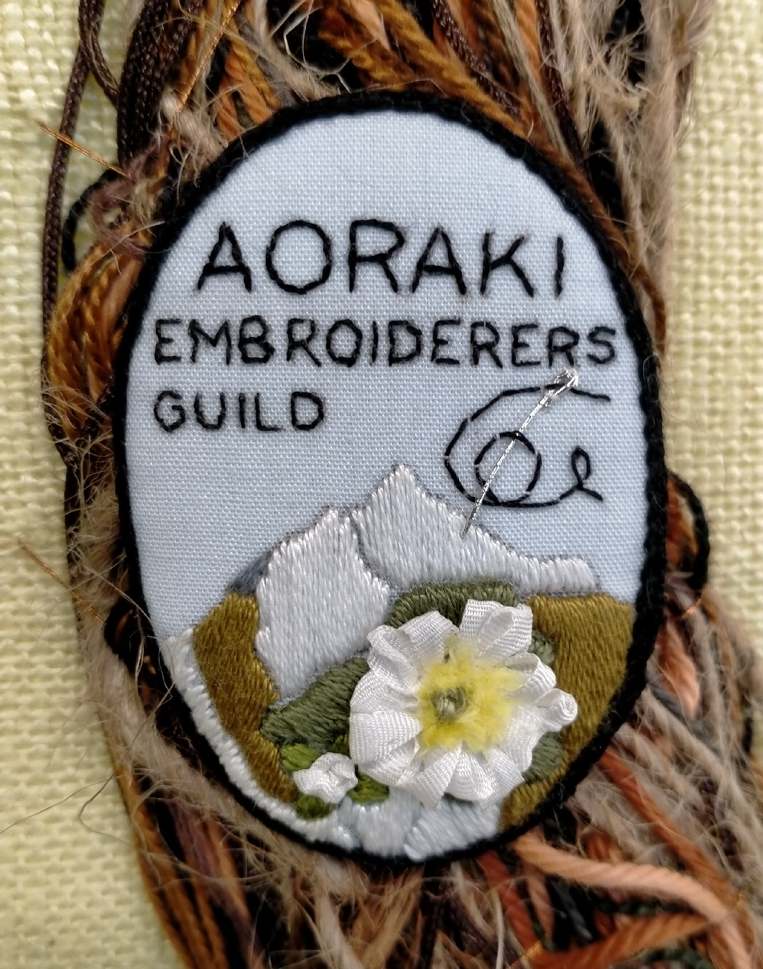 Aoraki Embroiderers' Guild logo photographed at the Timaru Library, July 2024.