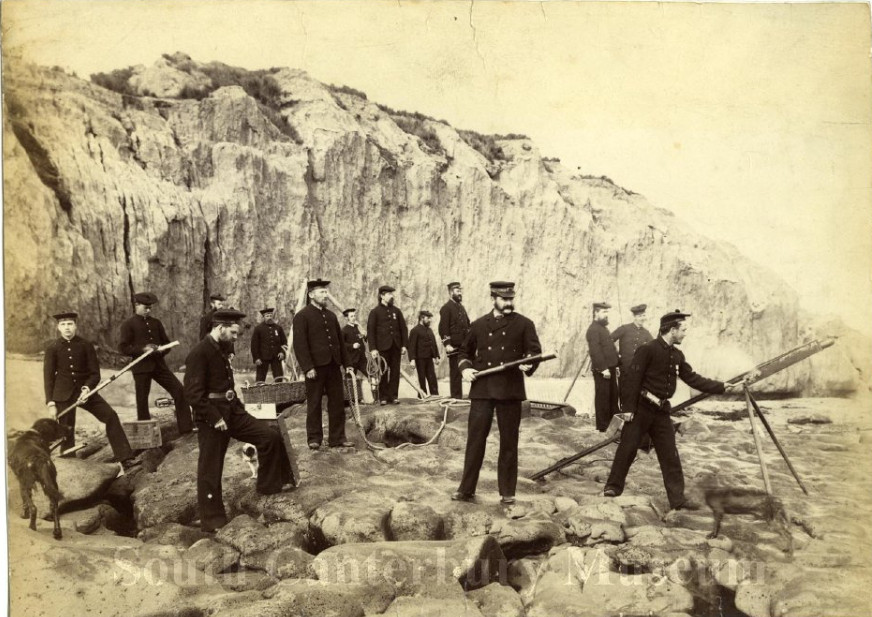 The Timaru Rocket Brigade posed as if practicing on the rocks below the cliffs on Caroline Bay, circa 1883.
Image courtesy of the South Canterbury Museum, item 0847. Please contact the museum for more information.
